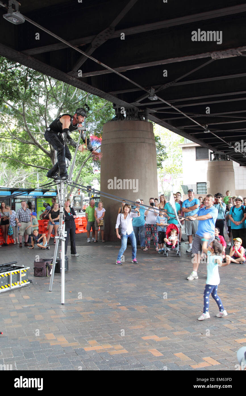 Street Artist juggling with burning torches during a performance at  Circular Quay, Sydney, Australia. Stock Photo