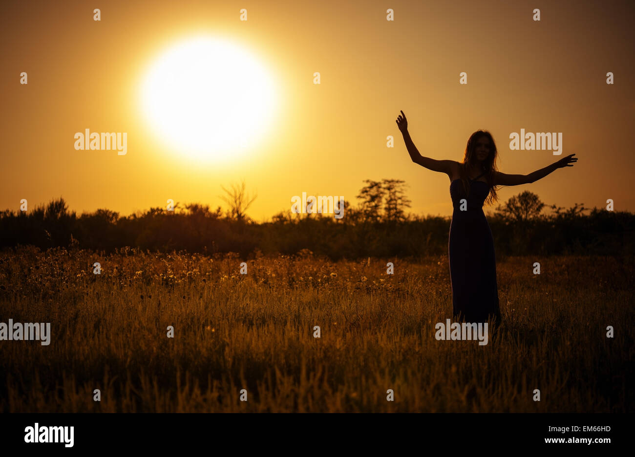 Silhouette of dancing young girl in dress against the sunset sky Stock ...