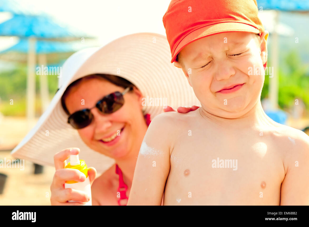 Mom puts on the baby's skin lotion for sun protection Stock Photo
