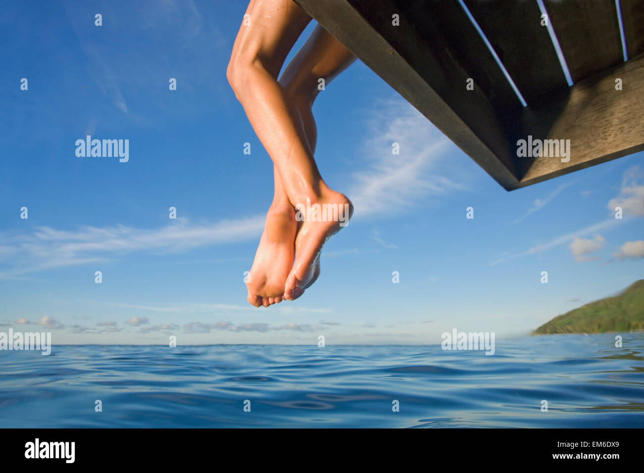 Hawaii, Womans Legs Hanging From Dock. Stock Photo