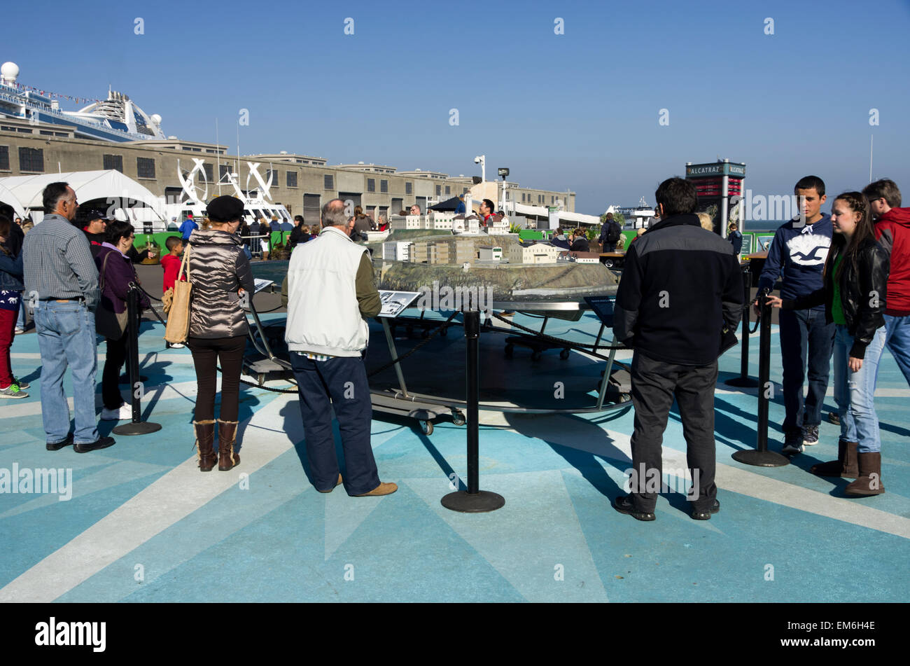 Alcatraz plaza, visitors look at model of the island prison while waiting for the boat. San Francisco Stock Photo