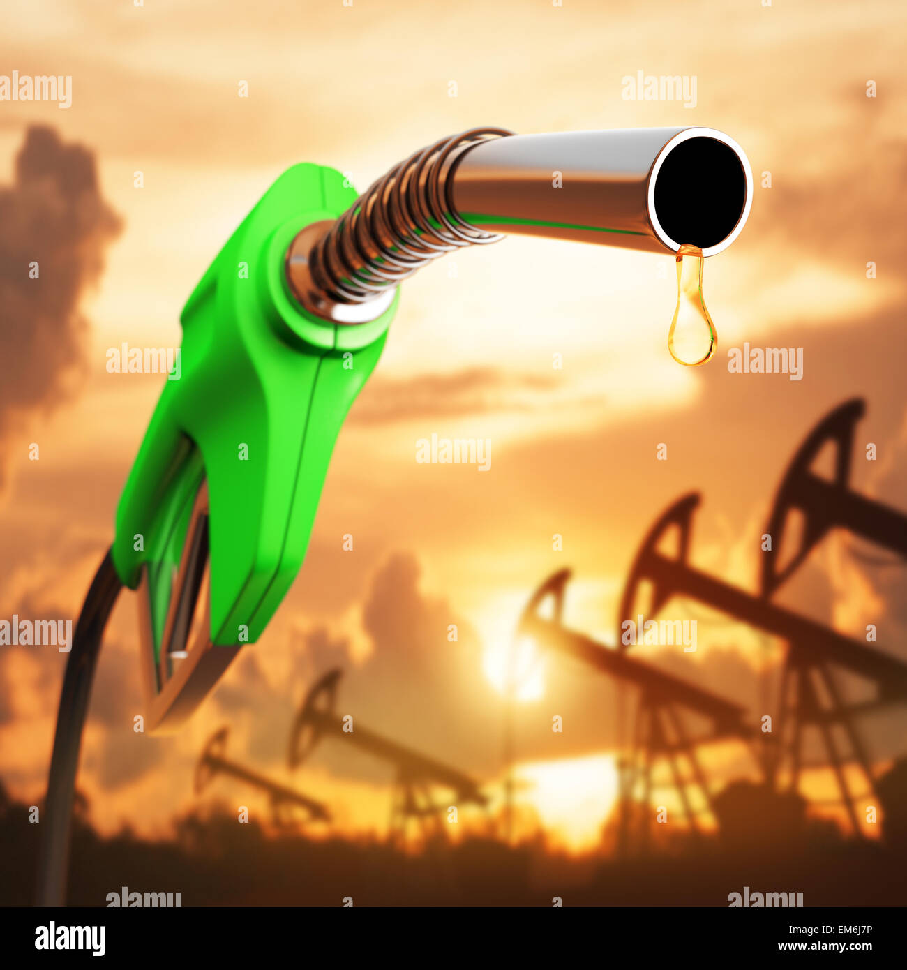 Gasoline drop down the pump with the sunset in the background. Depth of field at the drop. Stock Photo
