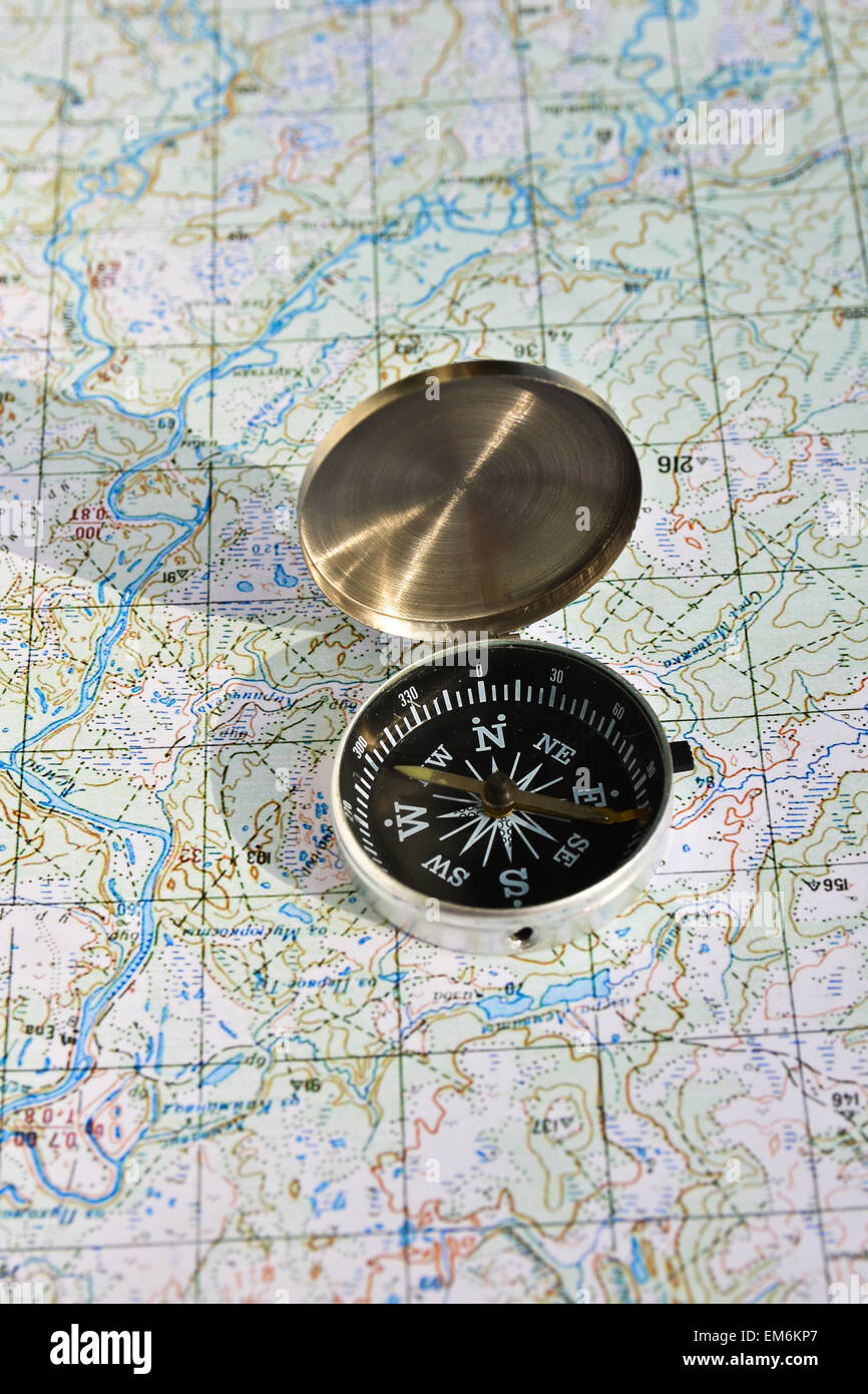 Geographical map and a compass. Photo magnetic compass located on a ...