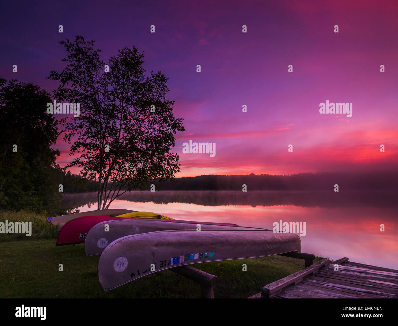 Sunrise explodes over Echo Lake in Aroostook State Park with canoes on