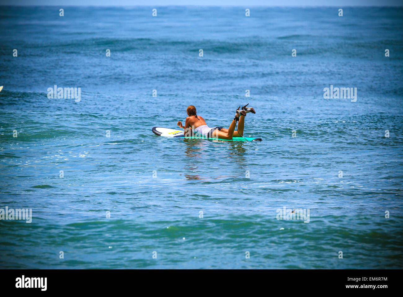 Surfer girl catches wave in high heels. Stock Photo