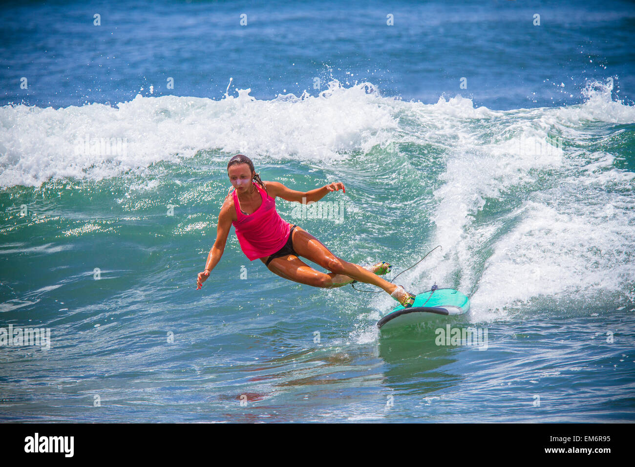 Surfer girl catches wave in high heels. Stock Photo