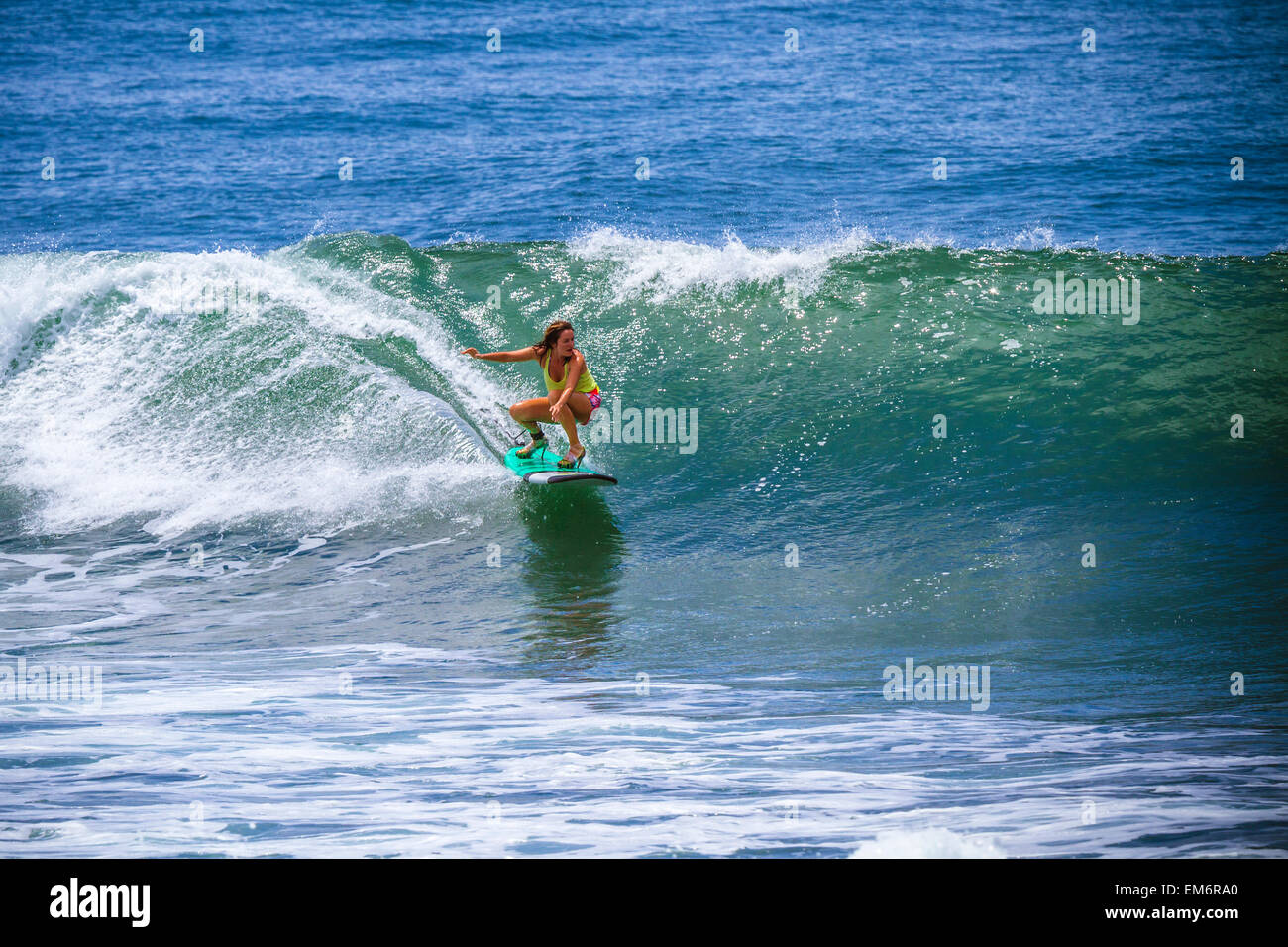 Surfer girl catches wave in high heels. Stock Photo