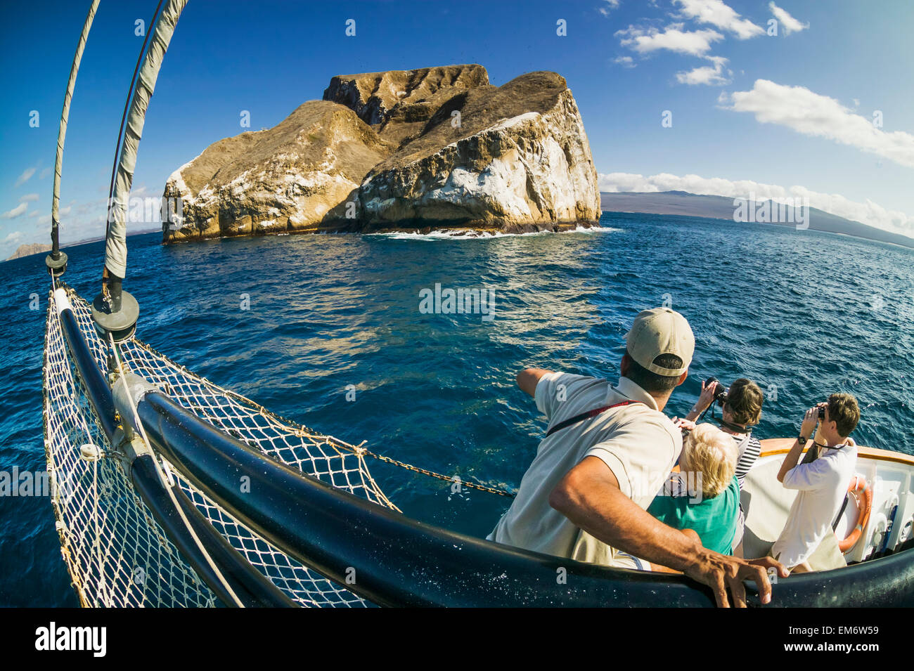 Tourists on board a travel and tourism ship with a view of Kicker Rock; Galapagos Islands, Ecuador Stock Photo