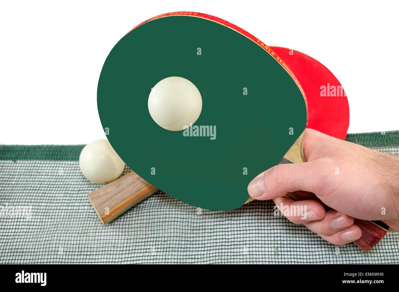 Male hand holding a ping pong racket and a table tennis ball above a net, isolated on white Stock Photo