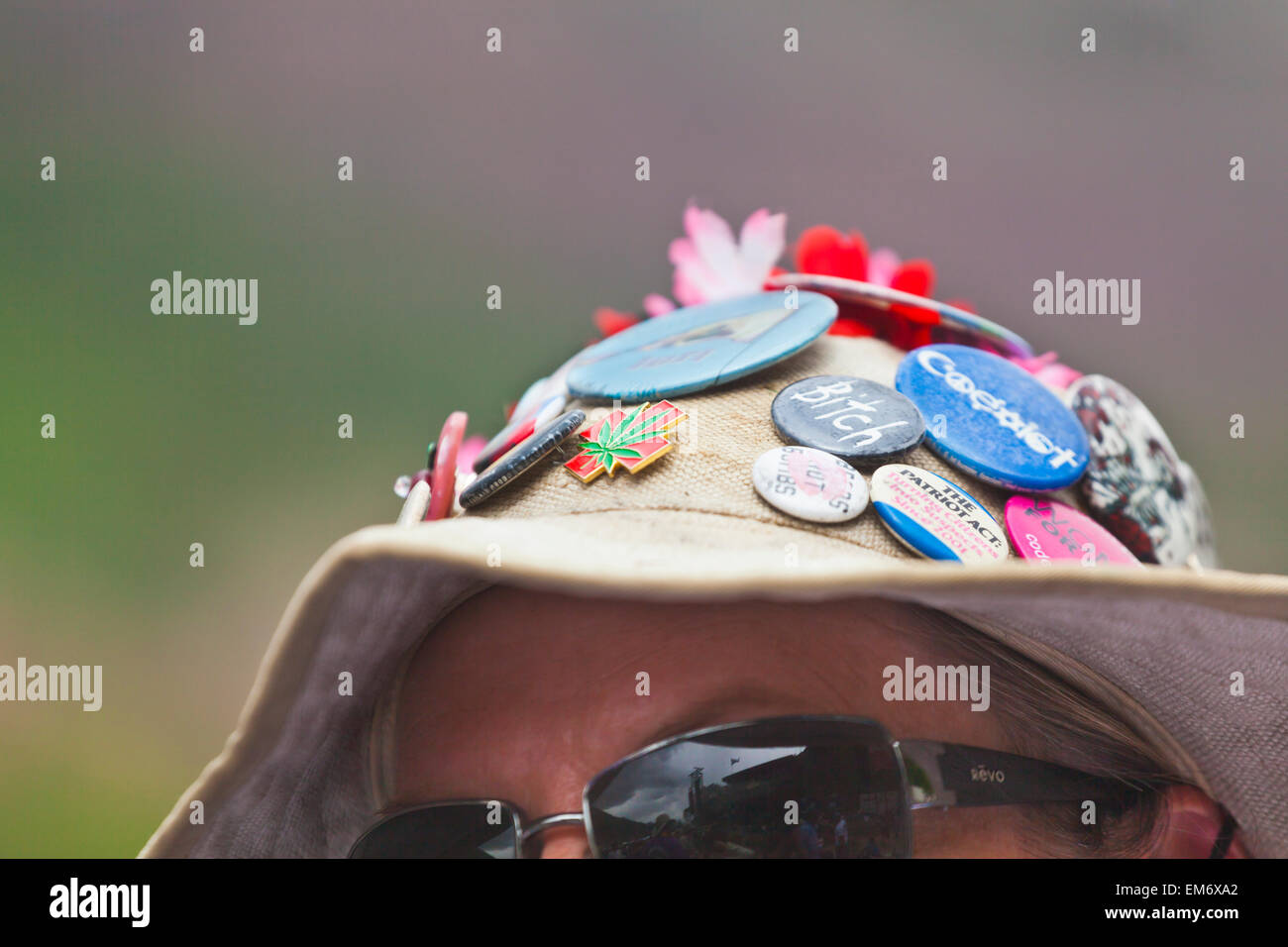 A woman wears a hat with various phrase buttons at the Telluride Bluegrass Festival in Telluride, Colorado. Stock Photo