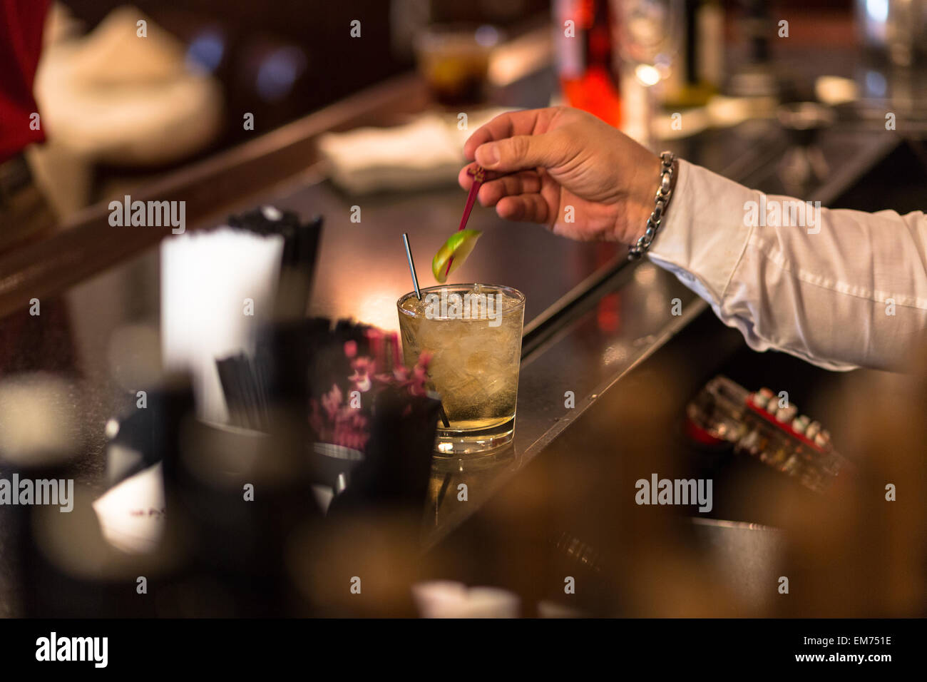 Bartender inserting slice of lime into cocktail Stock Photo