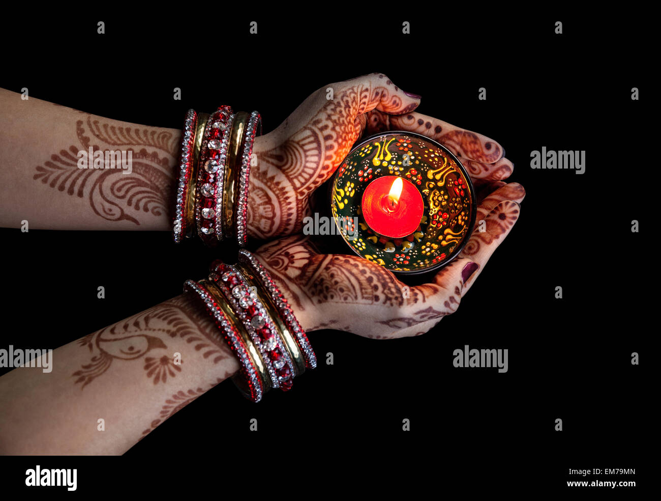 Woman hands with henna holding candle isolated on black background with clipping path Stock Photo