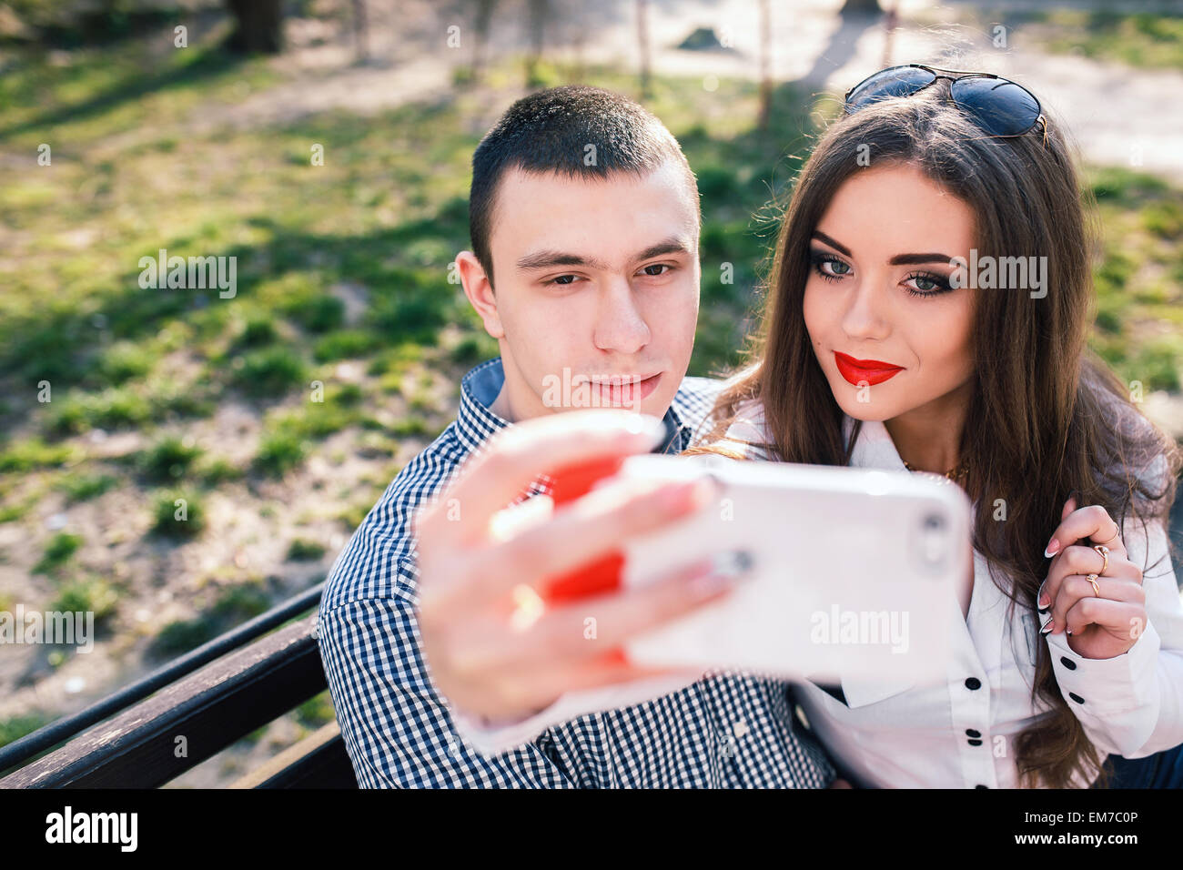 beautiful young couple having fun on a bench in the park Stock Photo ...