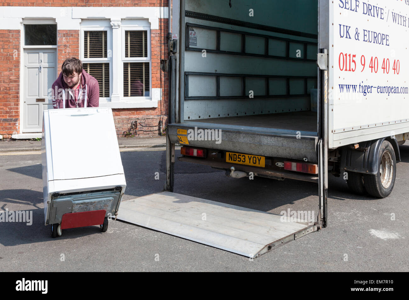 Moving house. A man loading white goods onto a tail lift of a hired self drive van, England, UK Stock Photo