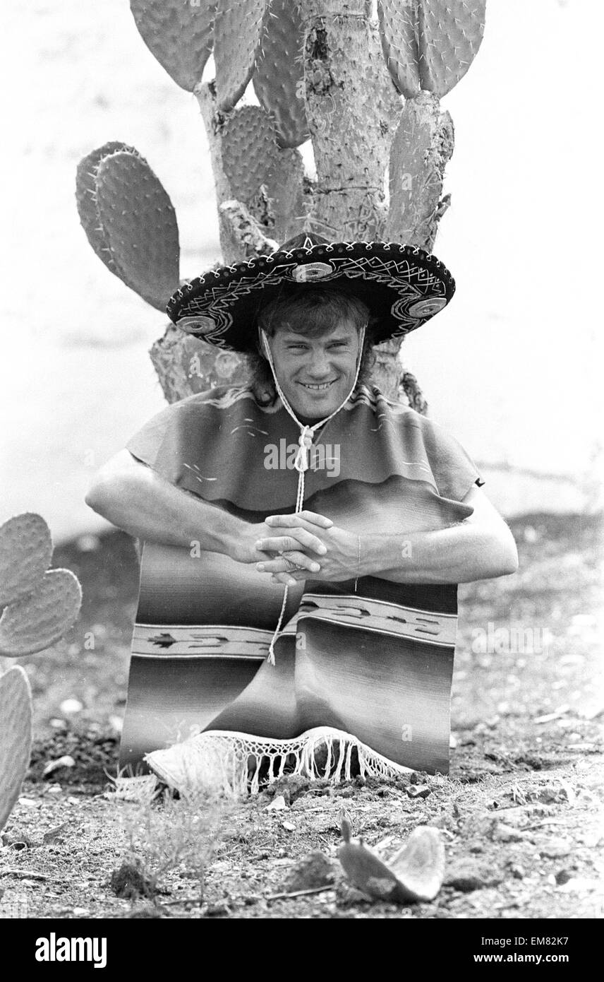 England footballer Glenn Hoddle poses as a Mexican bandit, sitting in front of a cactus at the team base in Monterrey, Mexico prior to the 1986 World Cup tournament. May 1986. Stock Photo