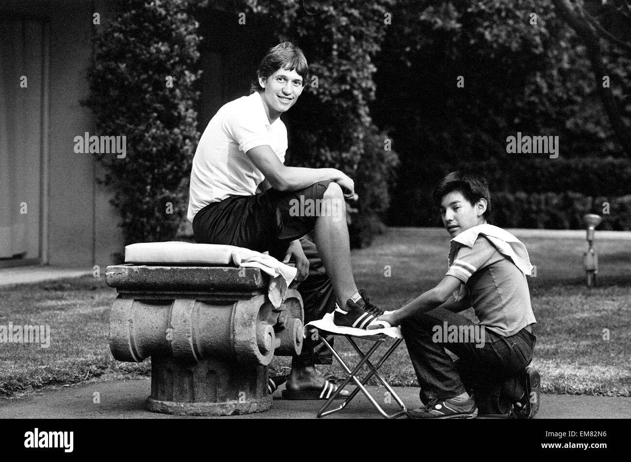 England footballer Gary Lineker has his boots cleaned by a shoe shine boy at the team base in Mexico during the 1986 World Cup tournament. June 1986. Stock Photo