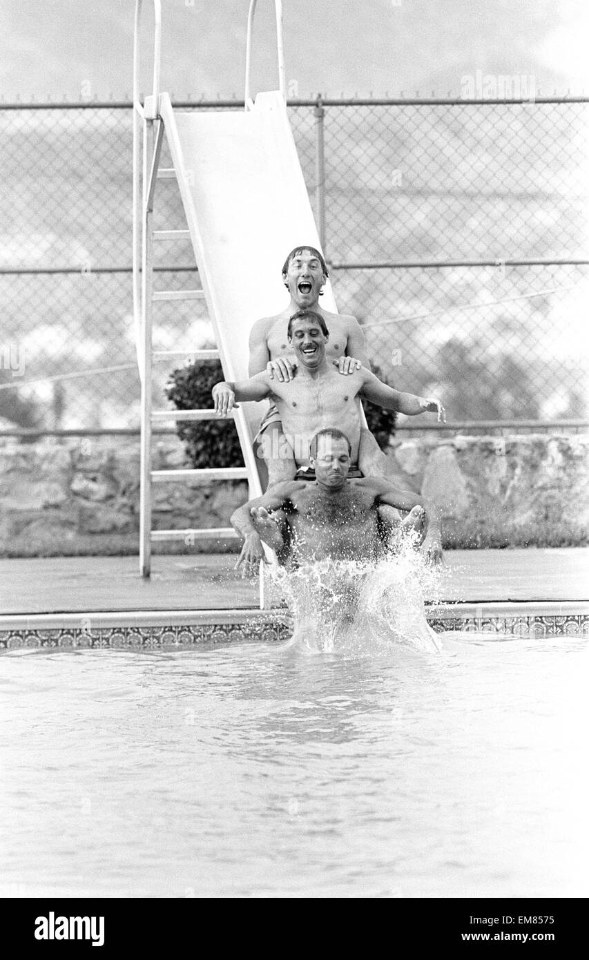 England footballers top to bottom: Terry Butcher, Kenny Sansom and Ray Wilkins slides into the swimming pool at the Cima Club in Monterrey, Mexico where the England team are based prior to the 1986 World Cup tournament. 27th May 1986. Stock Photo