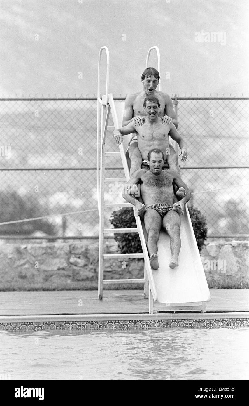 England footballers top to bottom: Terry Butcher, Kenny Sansom and Ray Wilkins slides into the swimming pool at the Cima Club in Monterrey, Mexico where the England team are based prior to the 1986 World Cup tournament. 27th May 1986. Stock Photo