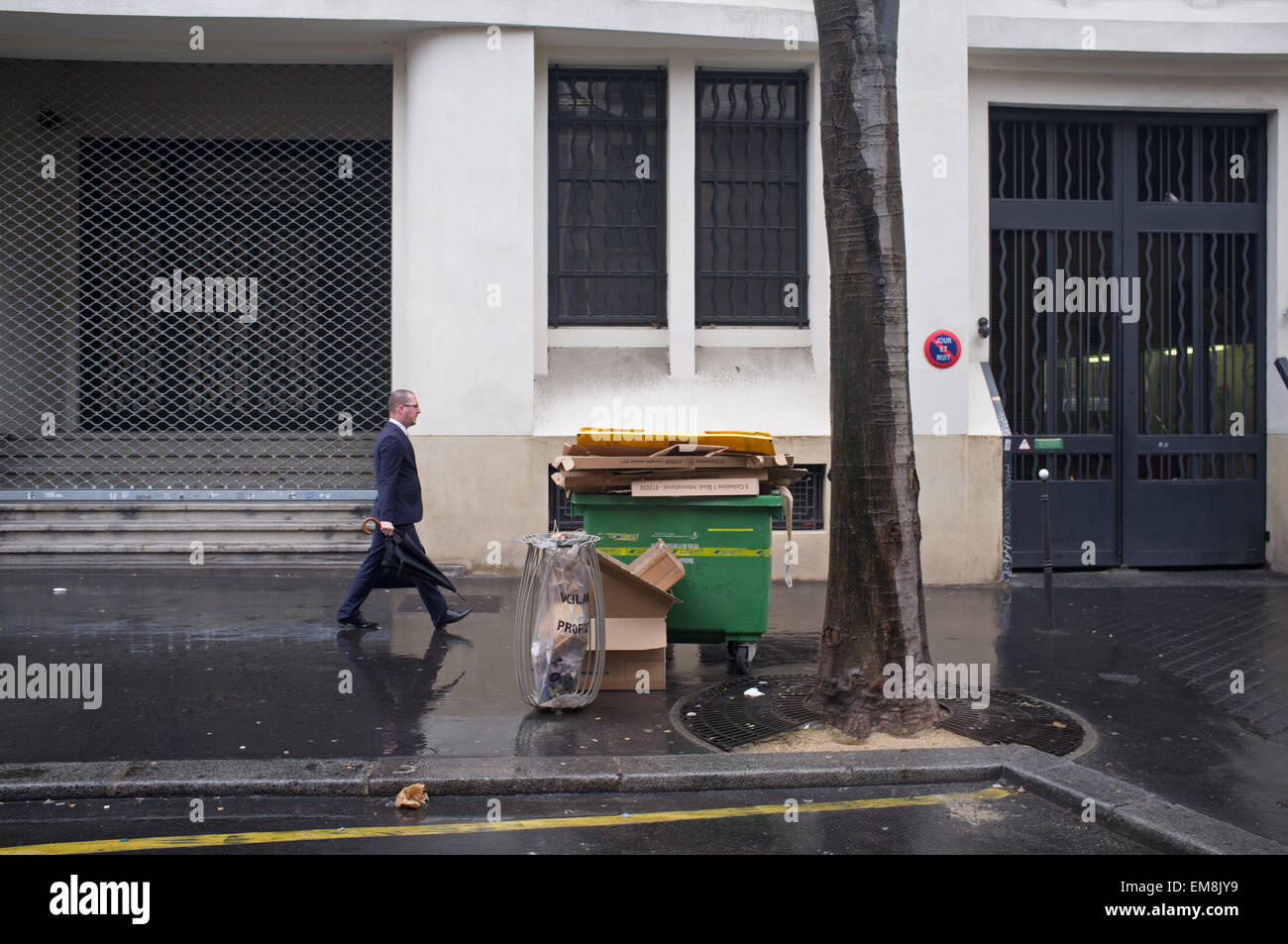 A man walking past uncollected rubbish in Paris, France Stock Photo