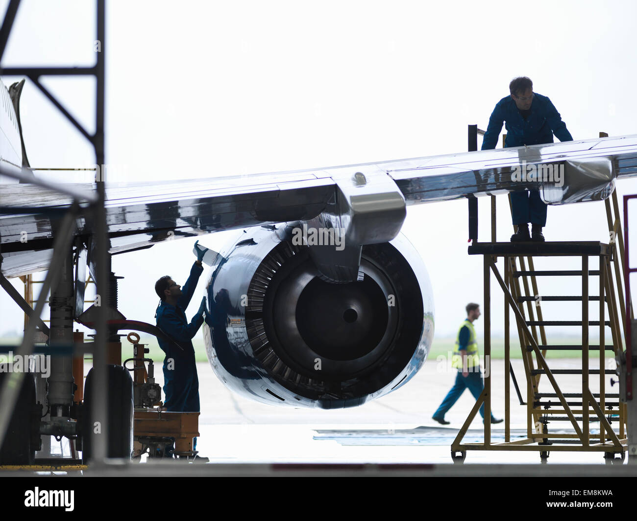Engineers working on aircraft wing in aircraft maintenance factory Stock Photo