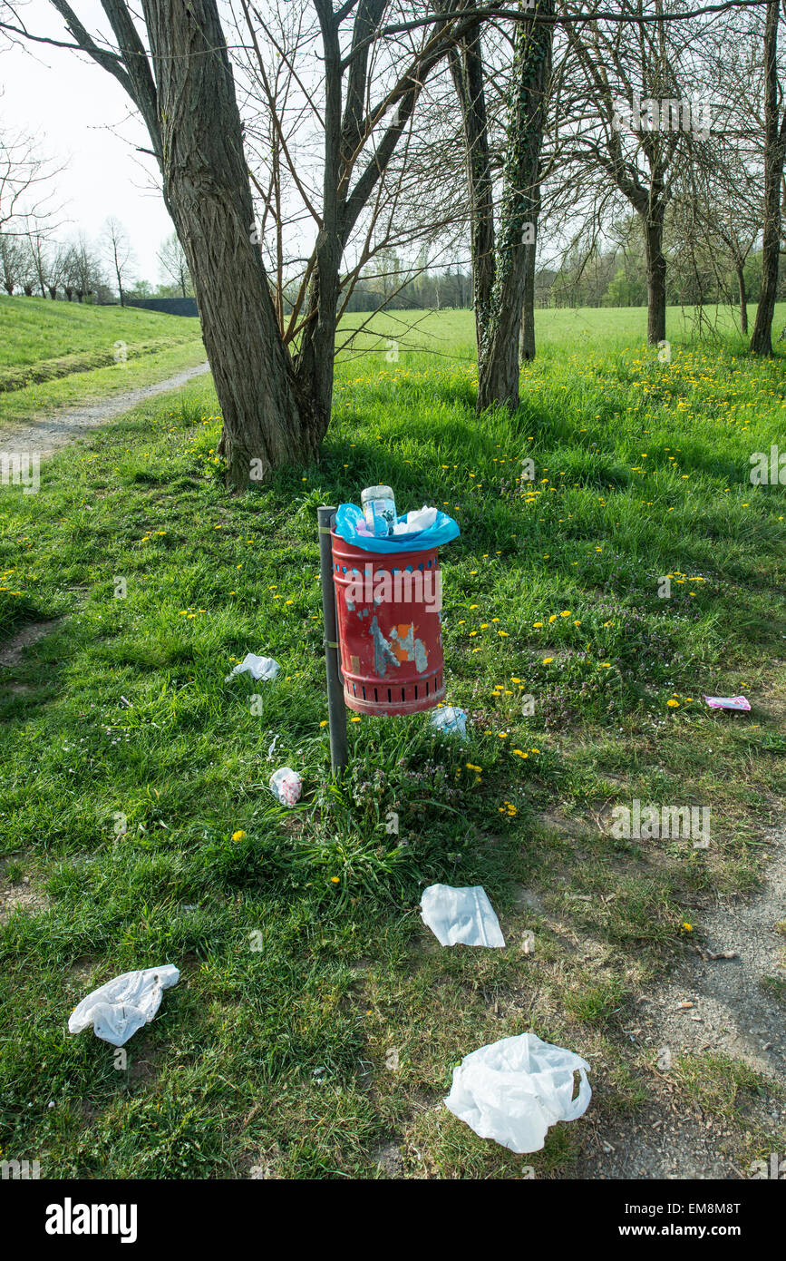 trash basket in the park and garbage on the lawn Stock Photo