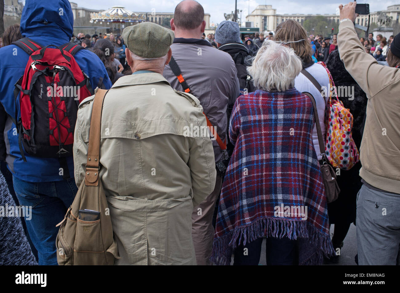 A mature couple in a crowd watch street entertainment in Paris Stock Photo
