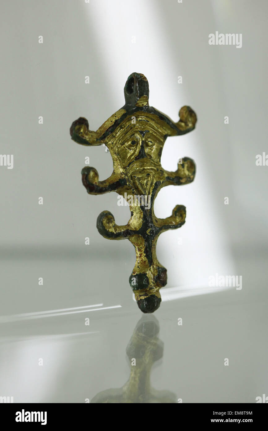 Great Moravian gilded bronze pendant with a human face and horns as a symbol of the Slavic pagan god Veles displayed at the exhibition 'Great Moravia and the Beginnings of Christianity' in Prague, Czech Republic. The pendant from the 8th century was discovered in the village of Hluk, South Moravia, Czech Republic. The exhibition presenting medieval treasures and original artefacts of the first Slavic state runs in Prague Castle till June 28, 2015. Stock Photo