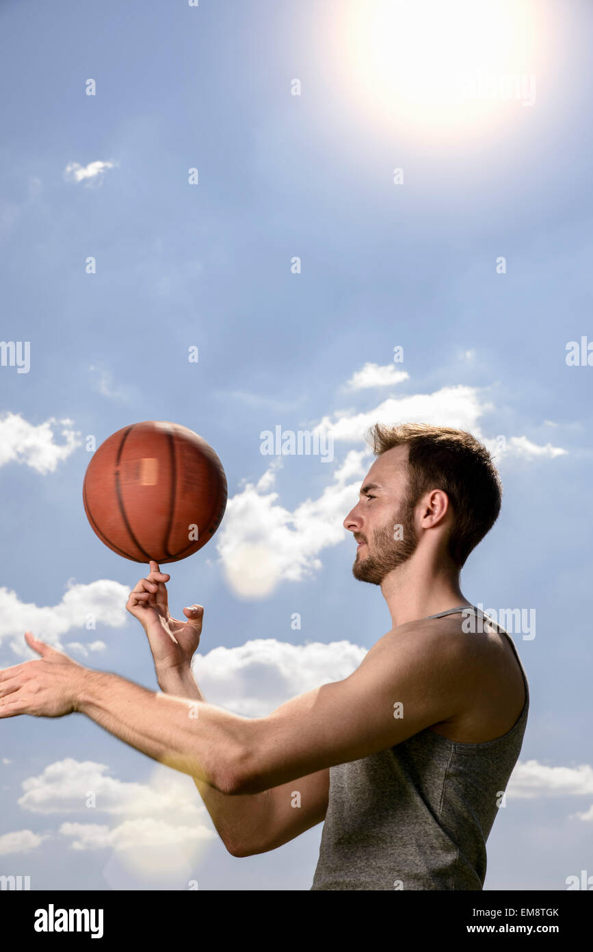 Young male basketball player spinning ball on finger Stock Photo
