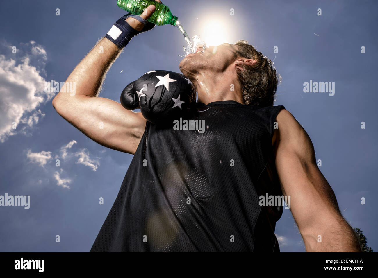 Low angle view of mid adult male boxer drinking bottled water Stock