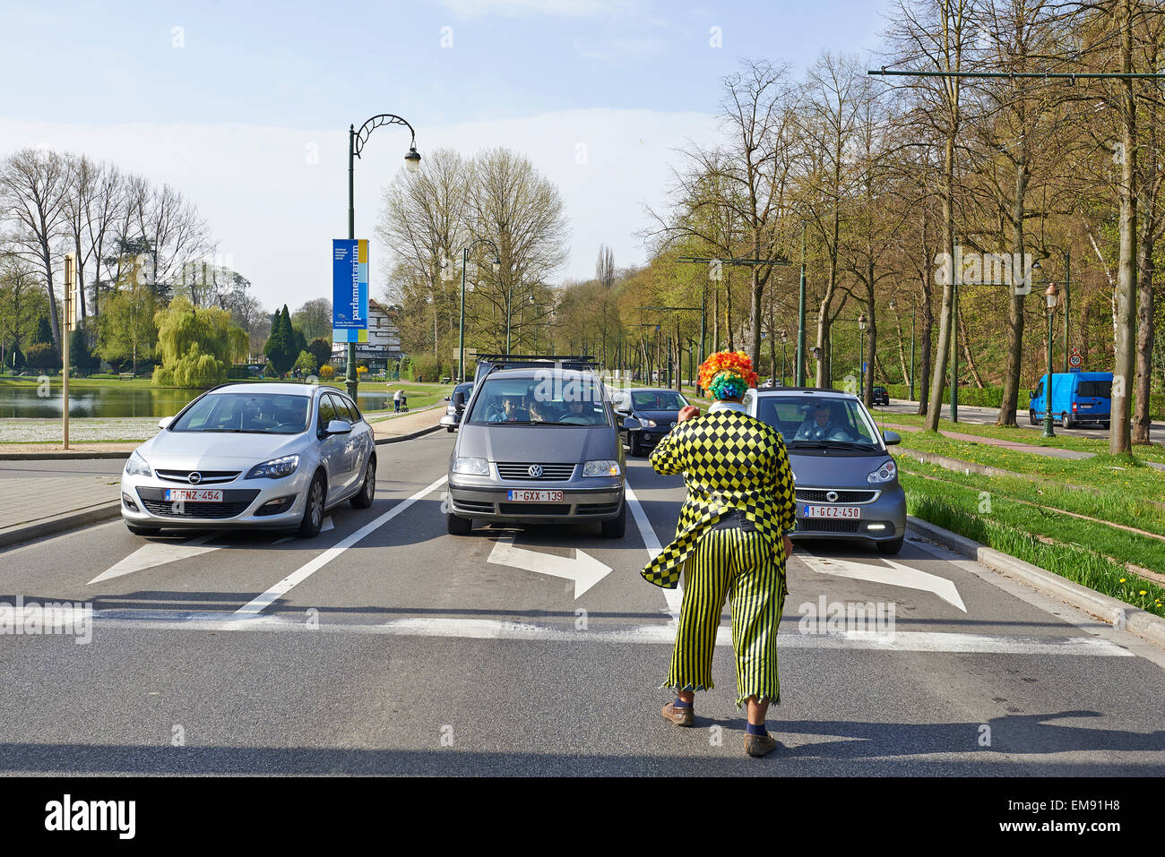 Here a Clown juggler perform for the stopped traffic in Brussels, Belgium. Stock Photo