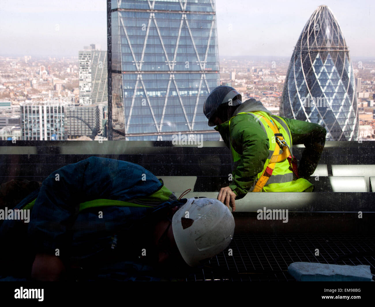 Maintenance workers at top of Walkie-Talkie building, City of London with Gherkin behind Stock Photo