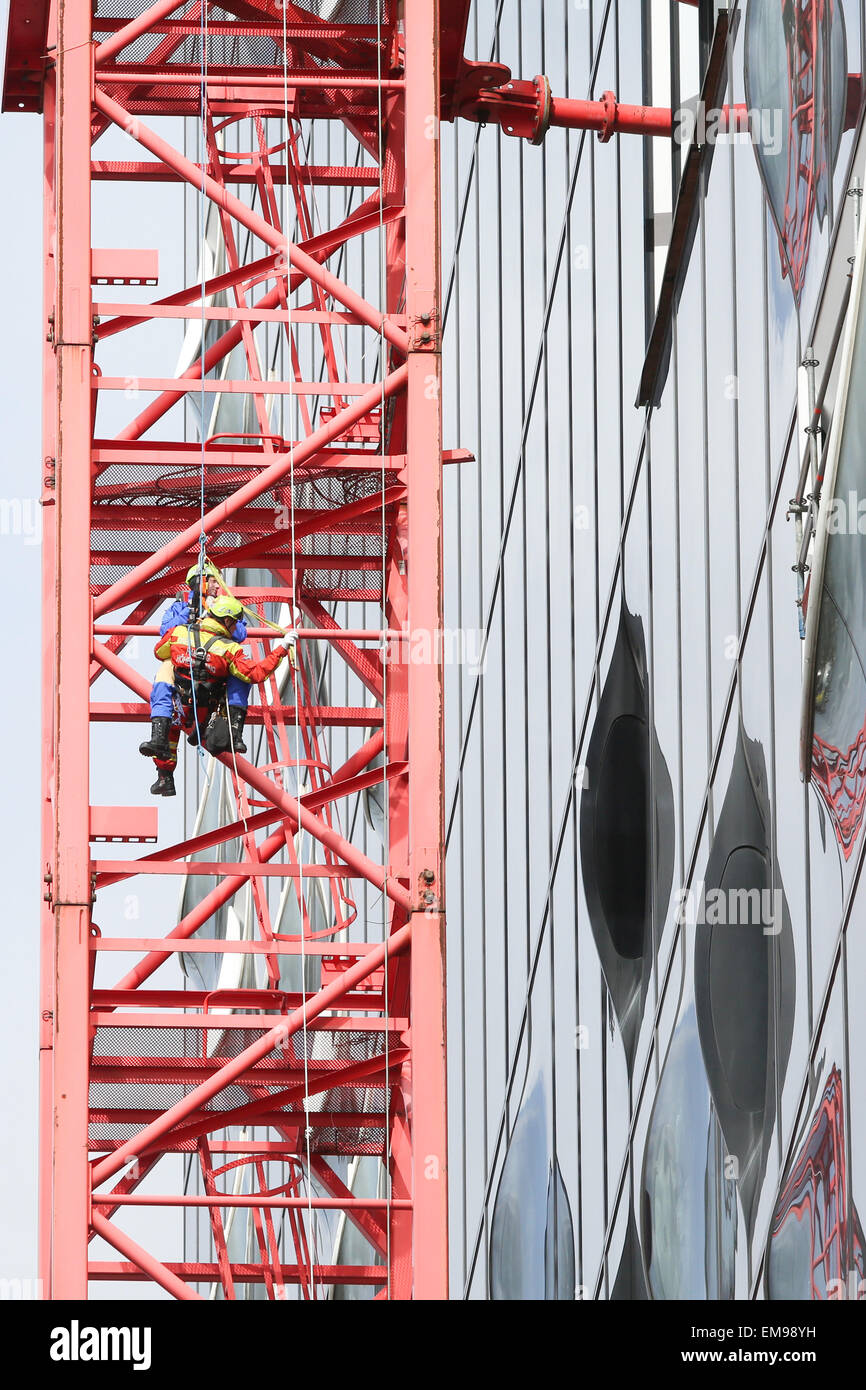 Hamburg, Germany. 13th Apr, 2015. High-altitude rescuers of the special operations unit of the Hamburg fire brigades (SEG-H) practice a rescue mission on a crane in front of the new Elbe Philharmonic Hall building in Hamburg, Germany, 13 April 2015. Photo: Bodo Marks/dpa/Alamy Live News Stock Photo