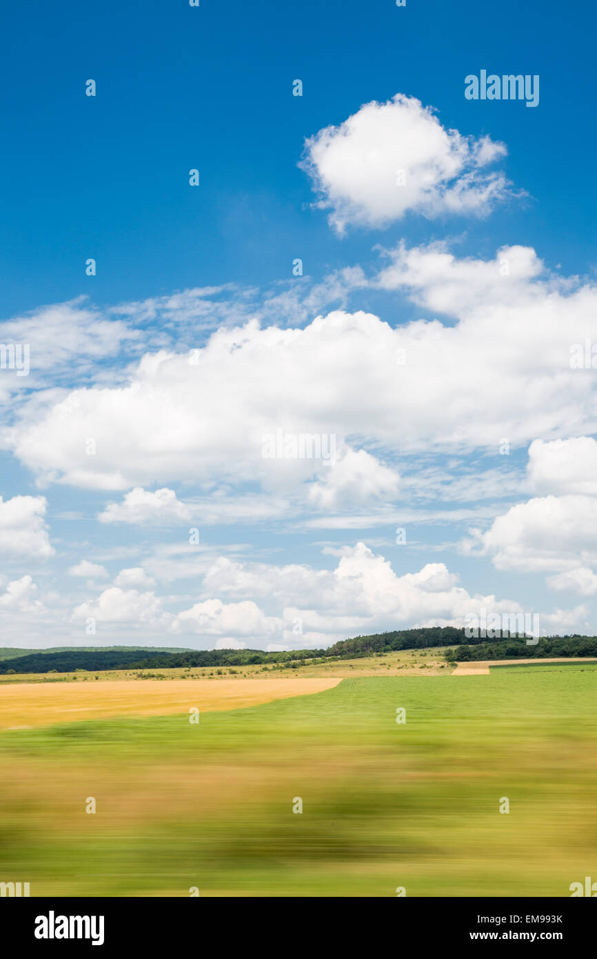 Panning landscape image taken from moving car of fields trees countryside sky near Balaton, Hungary Stock Photo