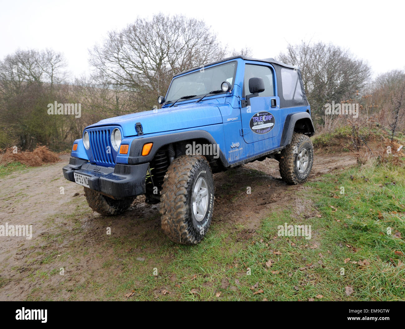 Modified Jeep Wrangler driving off road in deep wet mud and water Stock Photo