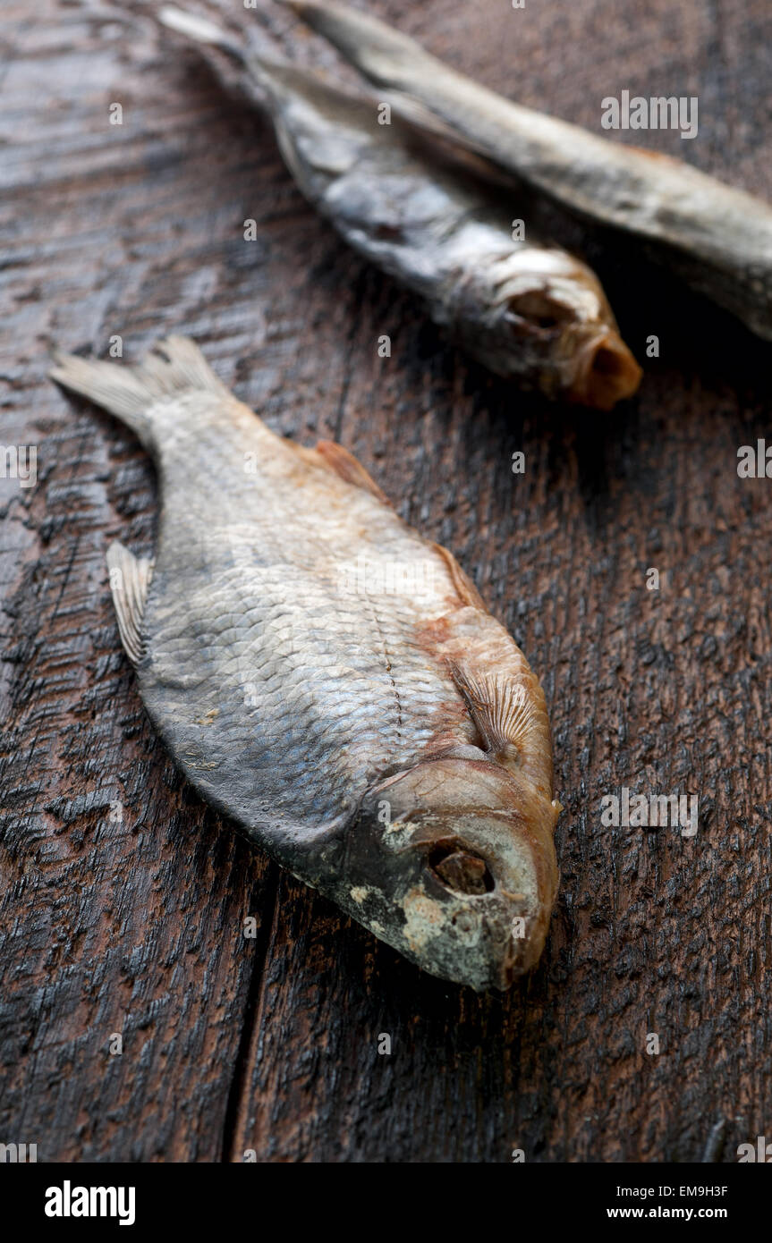 Salty dry river fish is  on a brown wooden background Stock Photo