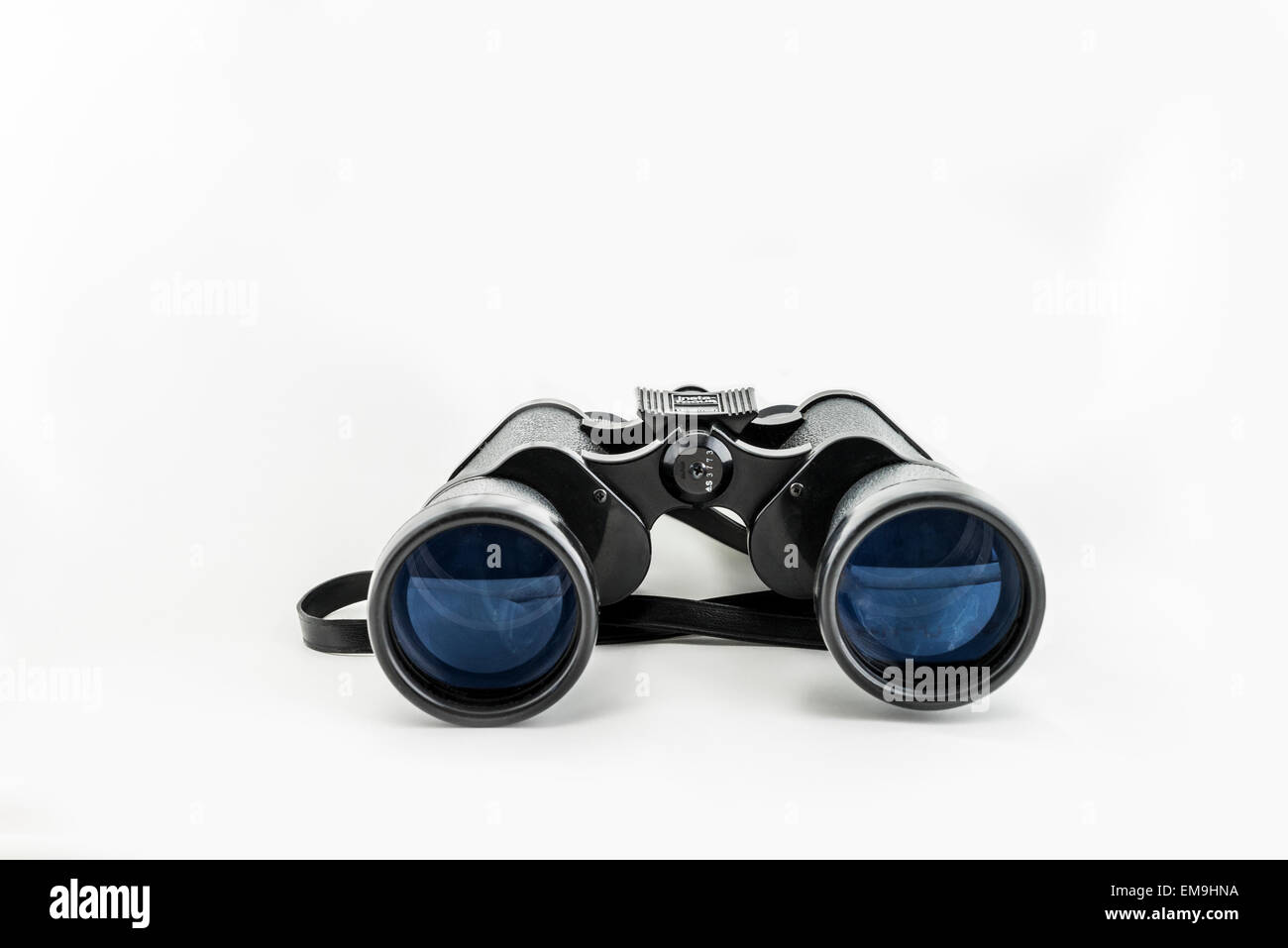 A pair of old Bushnell binoculars on a white background lens end