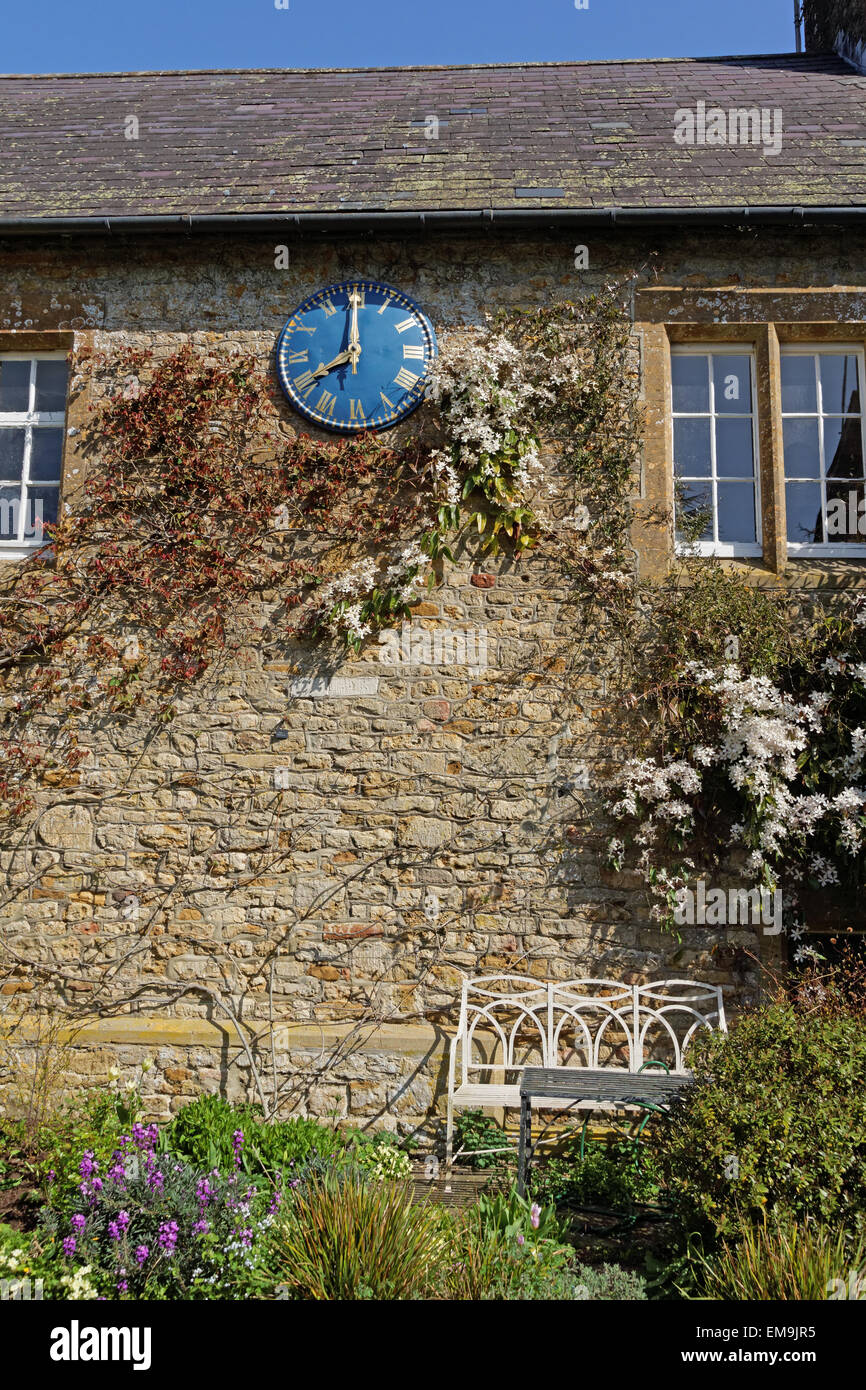 Blue clock on side of house in Dorset Stock Photo