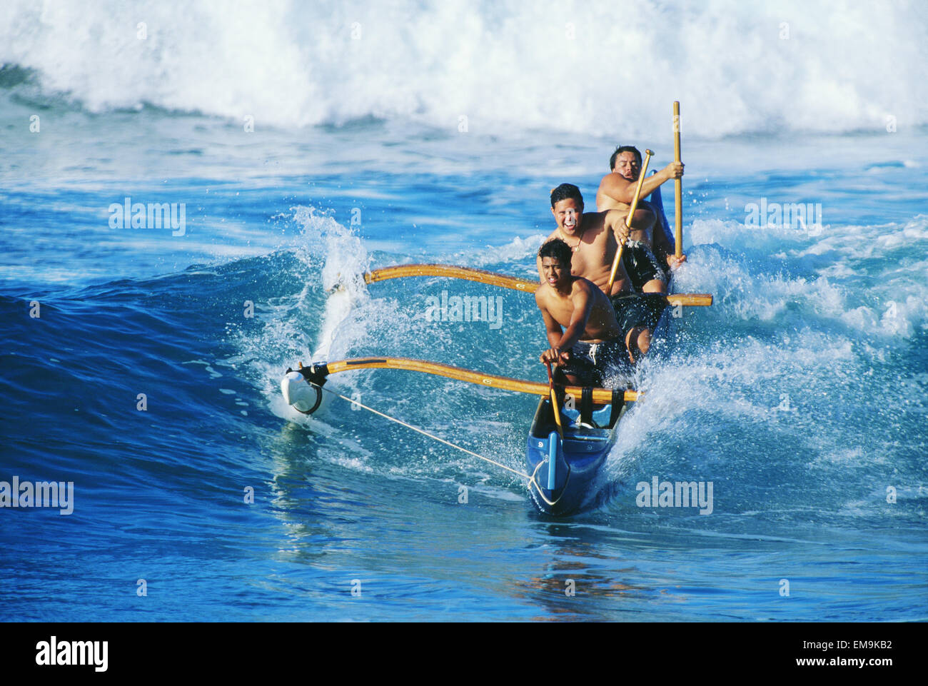 Hawaii, Oahu, Makaha Beach, Three Local Men In Outrigger Canoe Surfing