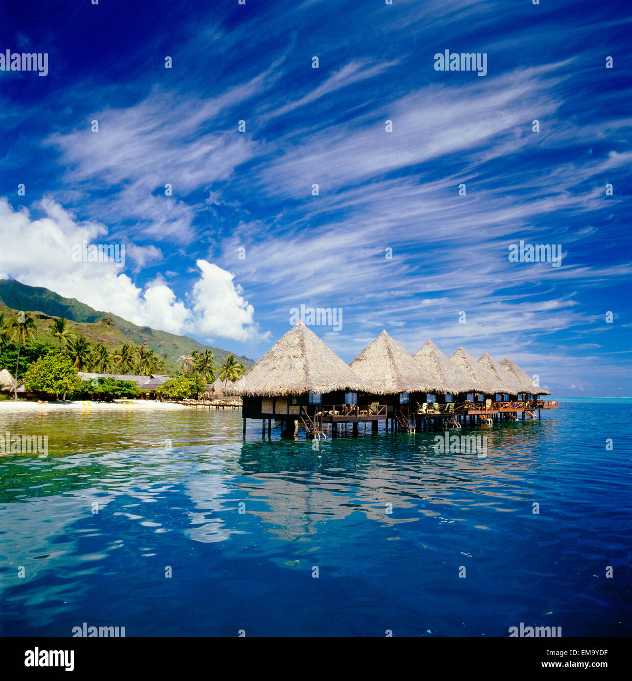 French Polynesia, Tahiti, Moorea, Bali Hai Resort Huts Over Water, Wispy  Clouds In Blue Sky Stock Photo - Alamy