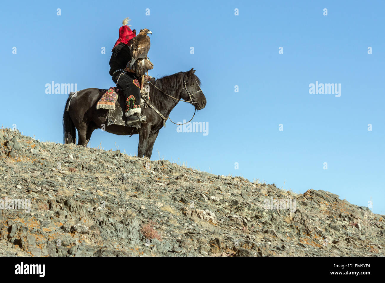 Hunter and eagle on mountain top, Western Mongolia Stock Photo