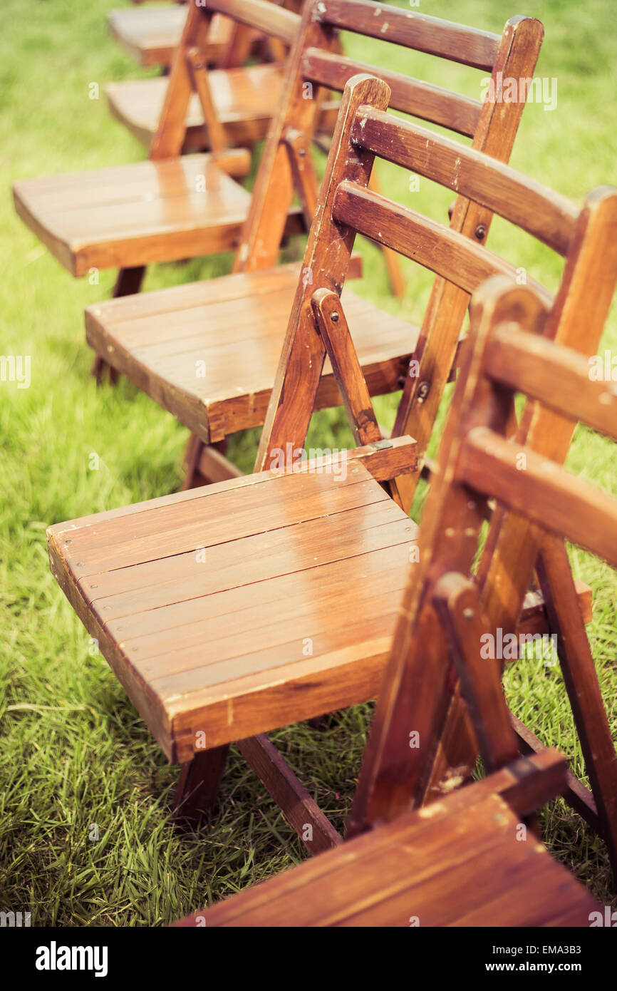 A line of vintage wooden folding school chairs at a country fair on