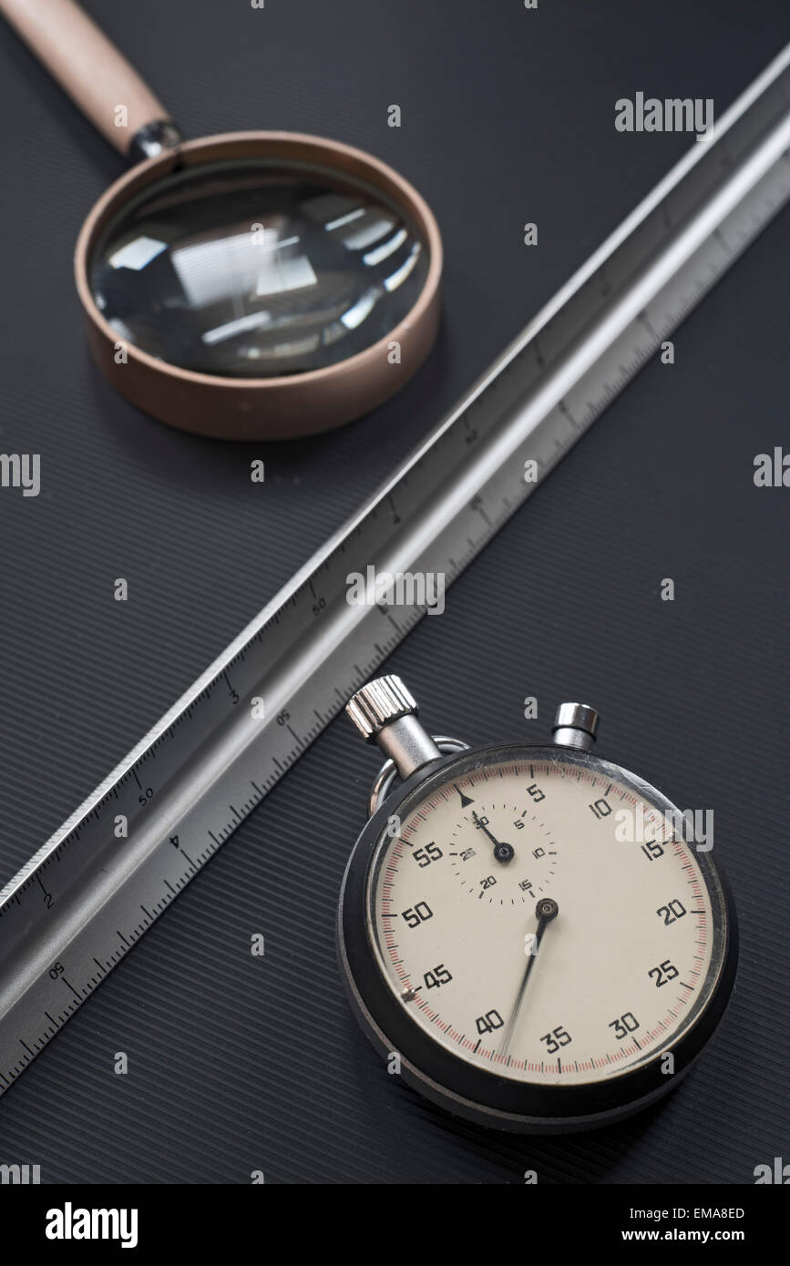 stopwatch, ruler and magnifying glass on black background Stock Photo ...