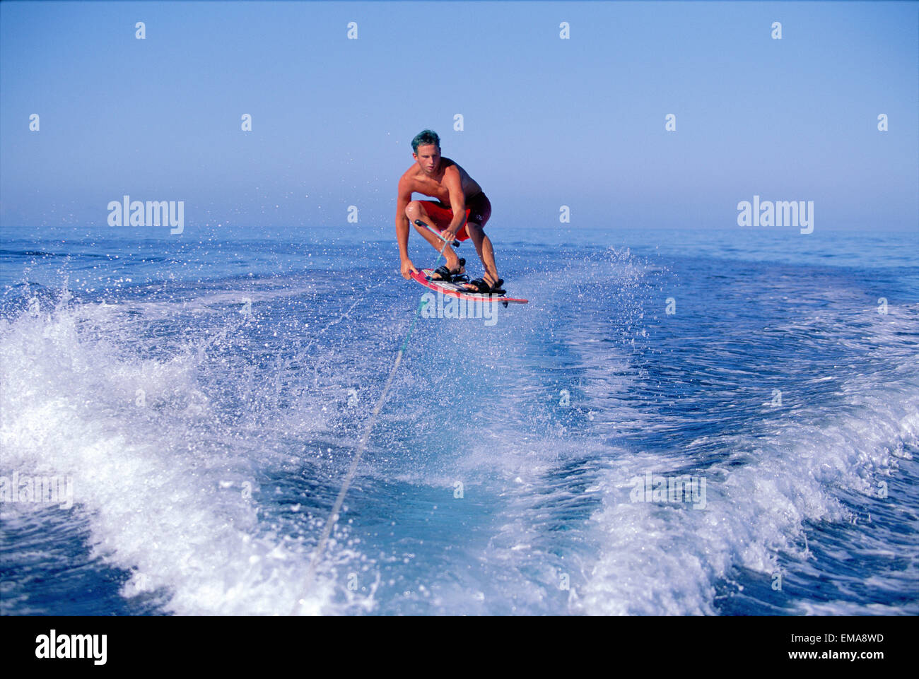 Hawaii, Maui, Ka'anapali, Lahaina Man Wakeboarding Jumping In Air, Calm Ocean Horizon Stock