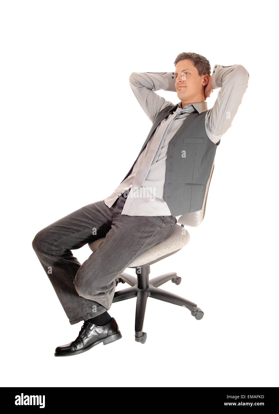 An business man in a shirt and vest sitting in a office chair, leaning
