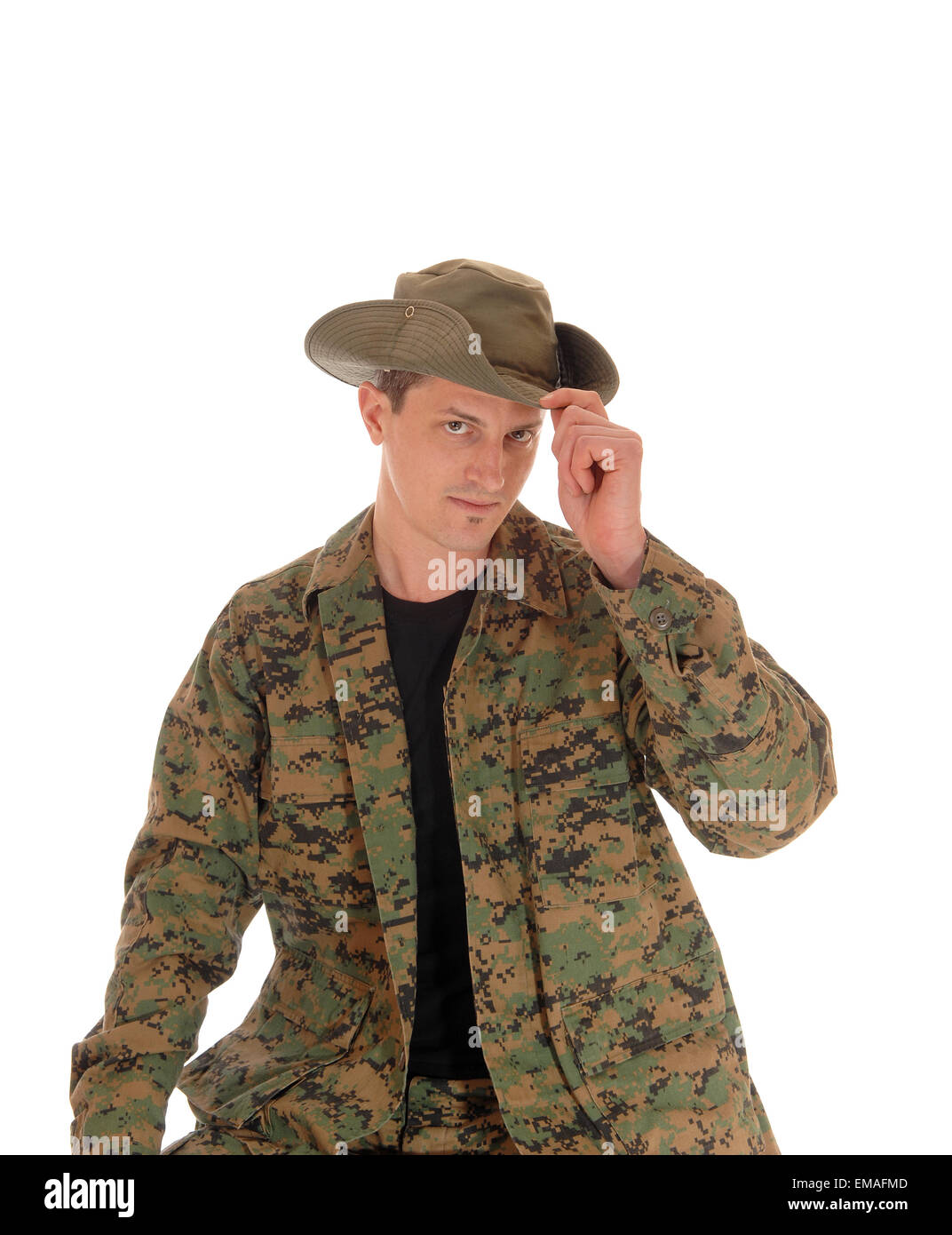 A young soldier sitting in camouflage uniform with his hand on his hat ...
