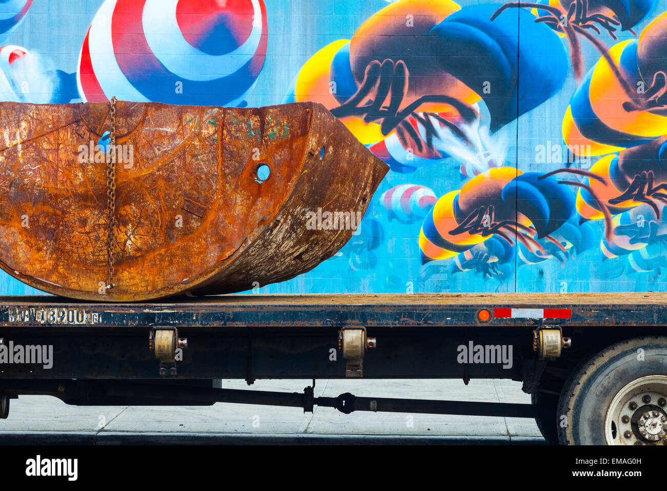 Abstract image of a flat bed truck with a rusting load with painted bees in the background Stock Photo