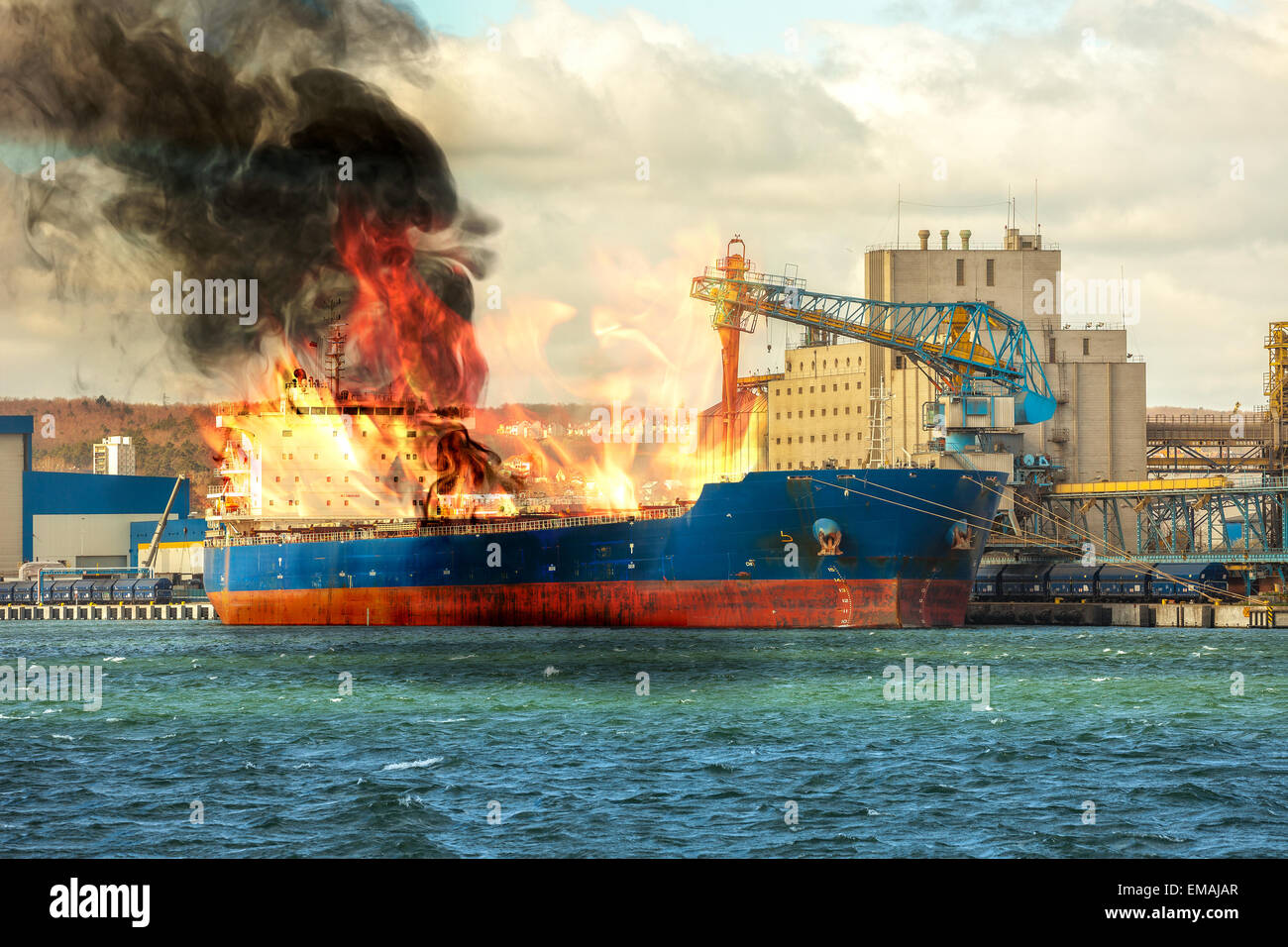 Burning cargo ship in the port. Stock Photo