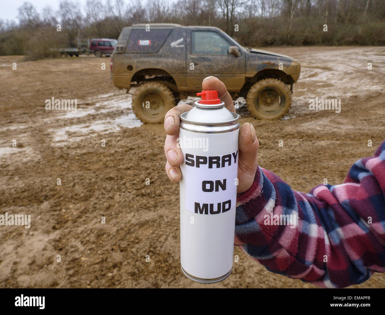 Spray on mud aerosol can with very muddy 4x4 in background Stock Photo