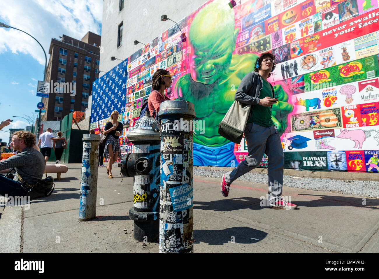 New York, USA 18 April 2016 - Bowery Mural featuring street artist Ron English with 'an American flag composed of Ron English's greatest hits.' According to Wikipedia English is 'One of the most prolific and recognizable artists alive today'!), whose work criticises consumerism and celebrity.   The Bowery Mural is at the corner of Houston and Bowery, the wall is owned by Goldman Properties, and since 2008 (with the help of Jeffery Deitch) has been curated with large-scale pieces by many known artists © Stacy Walsh Rosenstock Stock Photo