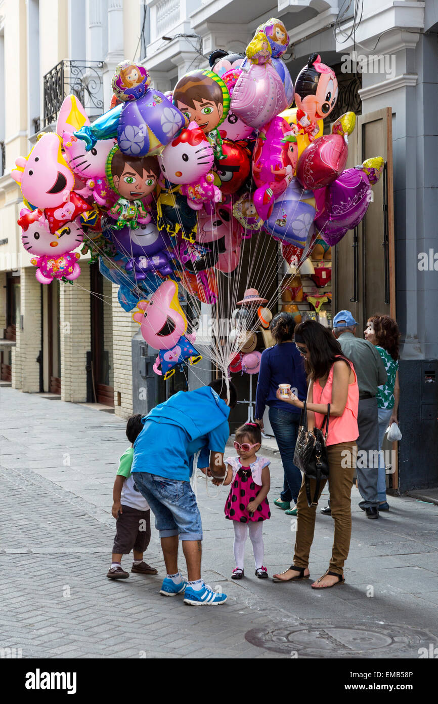 Lima, Peru.  Mother Buying a Balloon for her Child. Stock Photo